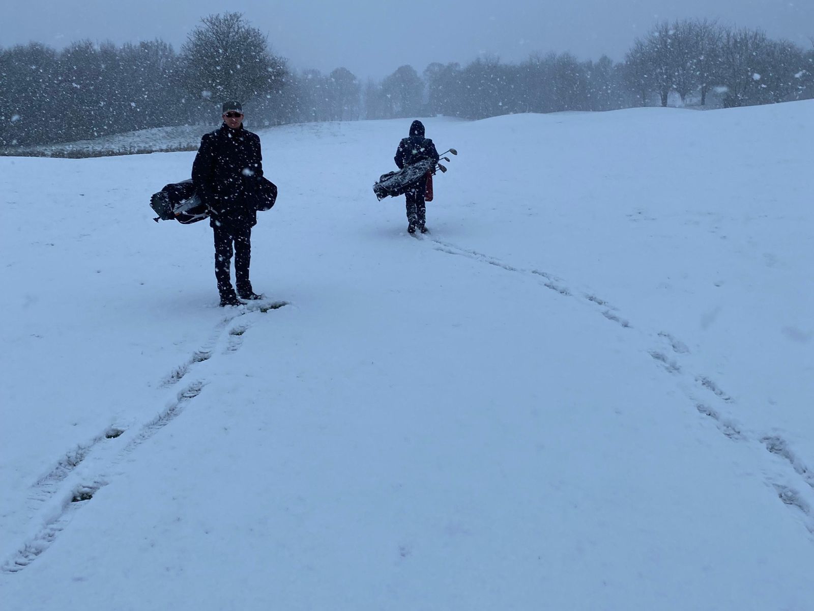 Mühlenhof Golf & Country Club - Zwei Golfer mit Bags auf dem verschneiten Platz im Wintergolf