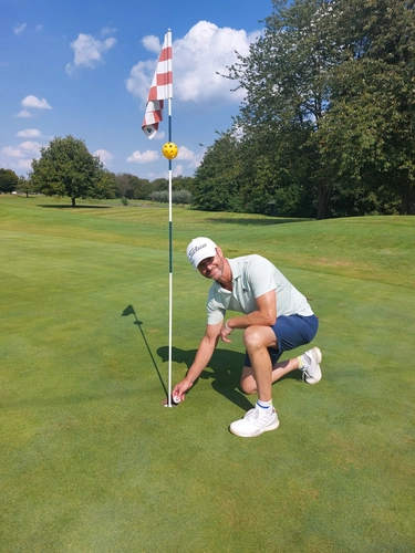 Mühlenhof Golf & Country Club e.V. – Jemand holt einen Golfball aus einem Loch auf dem Putting Green.